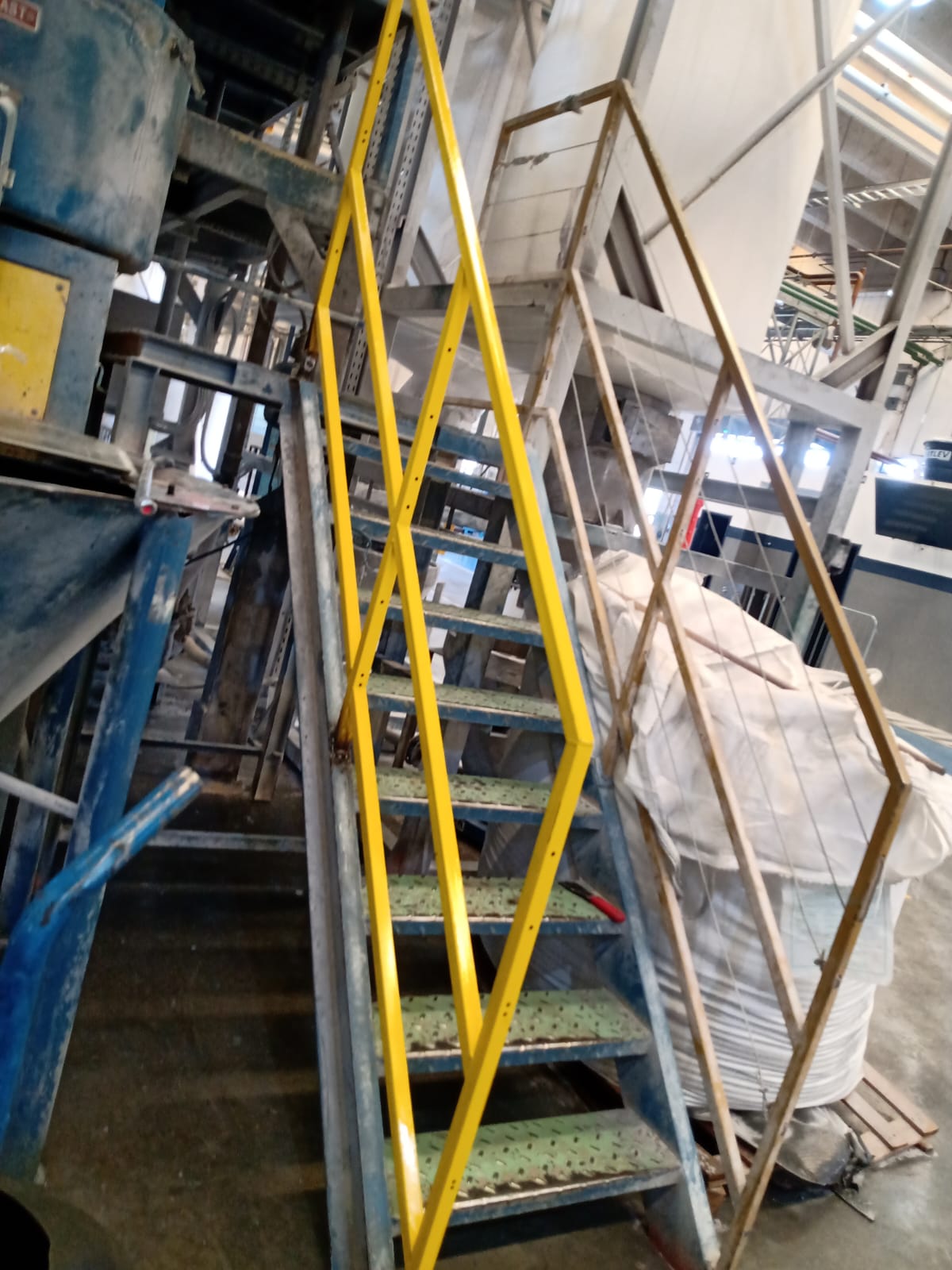 Escada industrial metálica com corrimão e plataforma