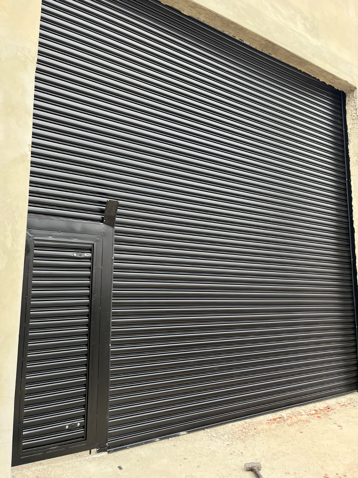 Porta de enrolar automática preta com portinhola social